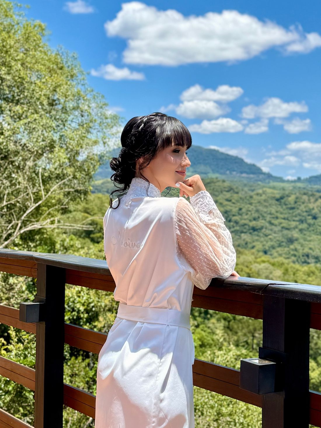 Noiva na varanda de uma cabana com vista para as montanhas