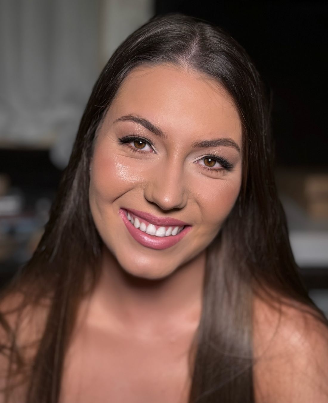 Cliente sorrindo com make rosada